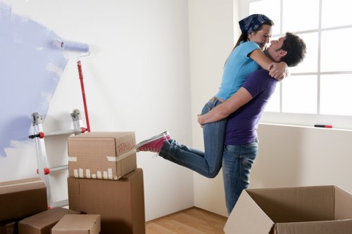 Movers handling fragile furniture with protective equipment