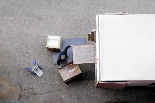 Piano removals team handling an upright piano in Ilford